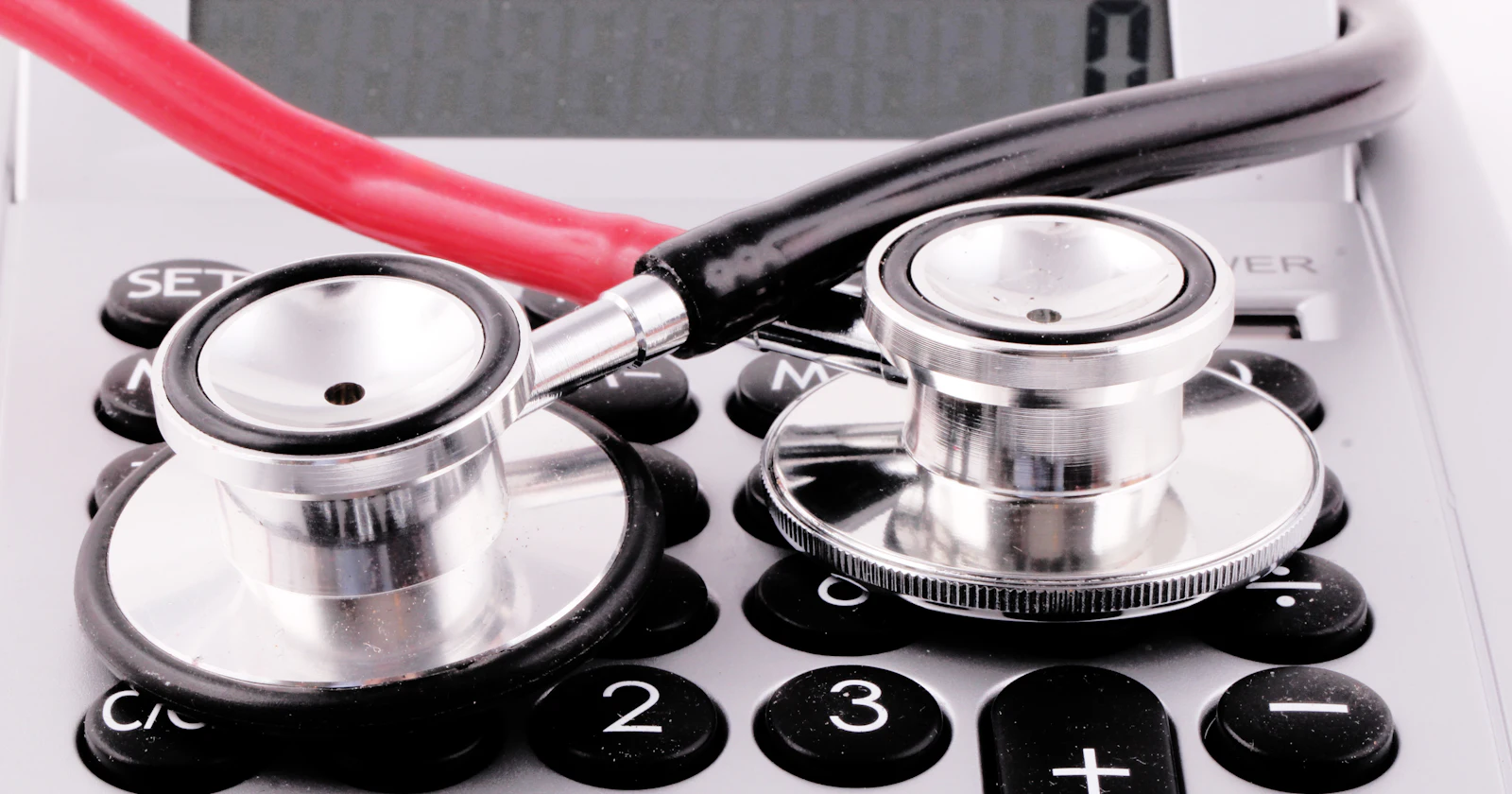 A stethoscope resting on top of a calculator.